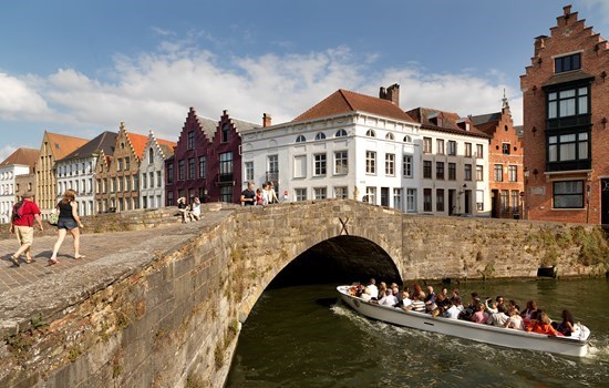 Boat passing under a bridge in Bruges, Belgium