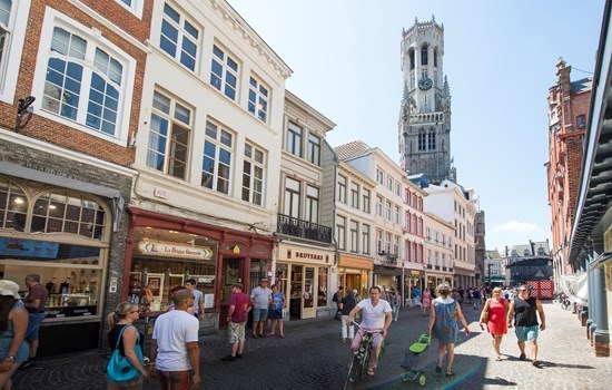 People shopping in the city center, in front of the belfry in Bruges, Belgium
